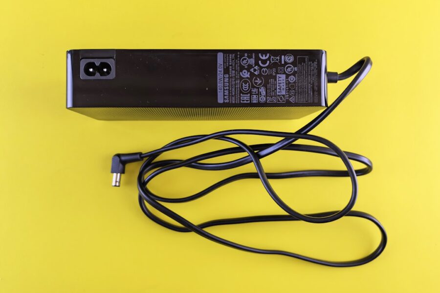 Black power adapter with cord on yellow background