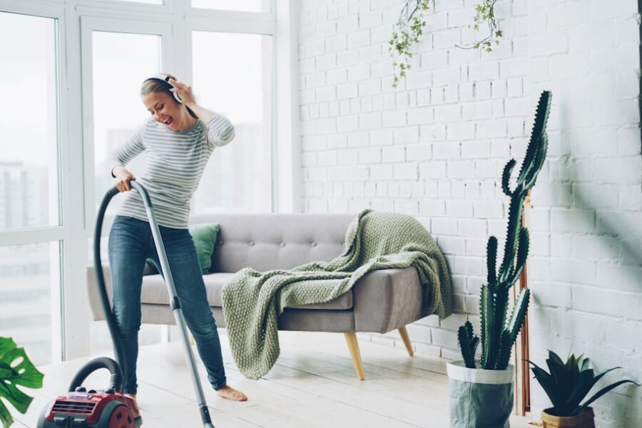 Woman happily vacuuming a bright, modern living room.