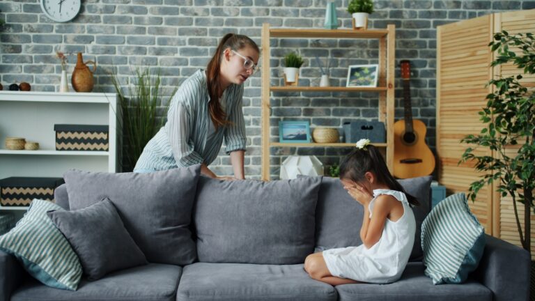 Siblings arguing sofa parent mediating kids conflict