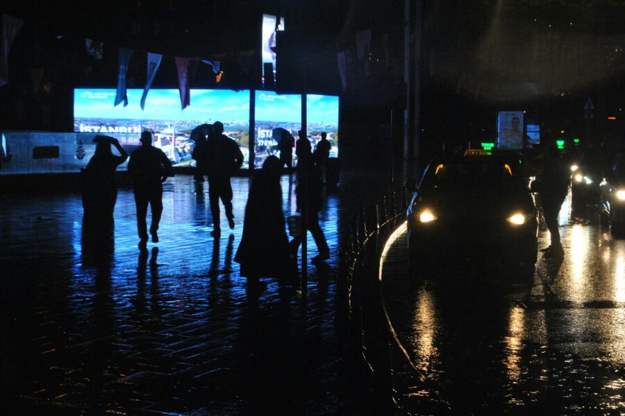 Rainy city street umbrellas reflections