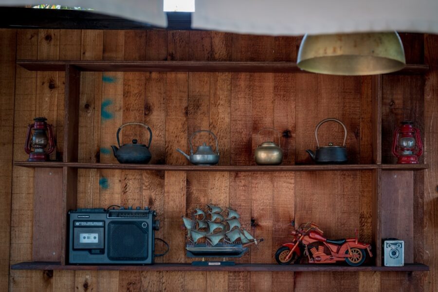 Wooden shelves display teapots, radio, and motorcycle.
