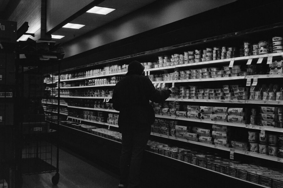 Woman grocery shopping handwritten list supermarket aisle