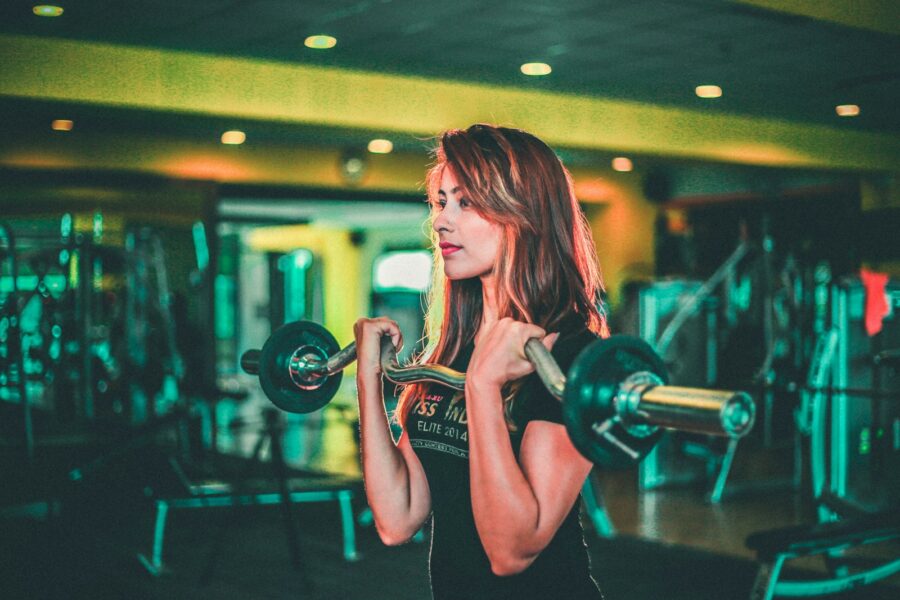 Gym woman lifting dumbbells strength training
