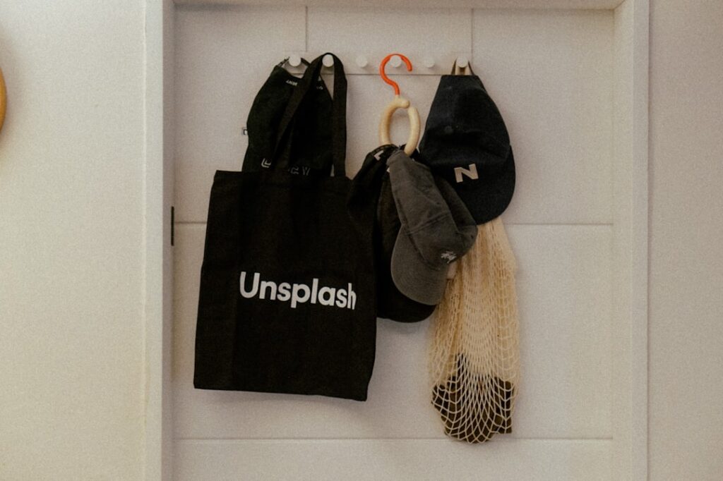 Black tote bag and caps hanging on hooks.
