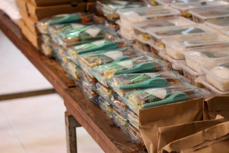 a table filled with plastic containers and bags of food