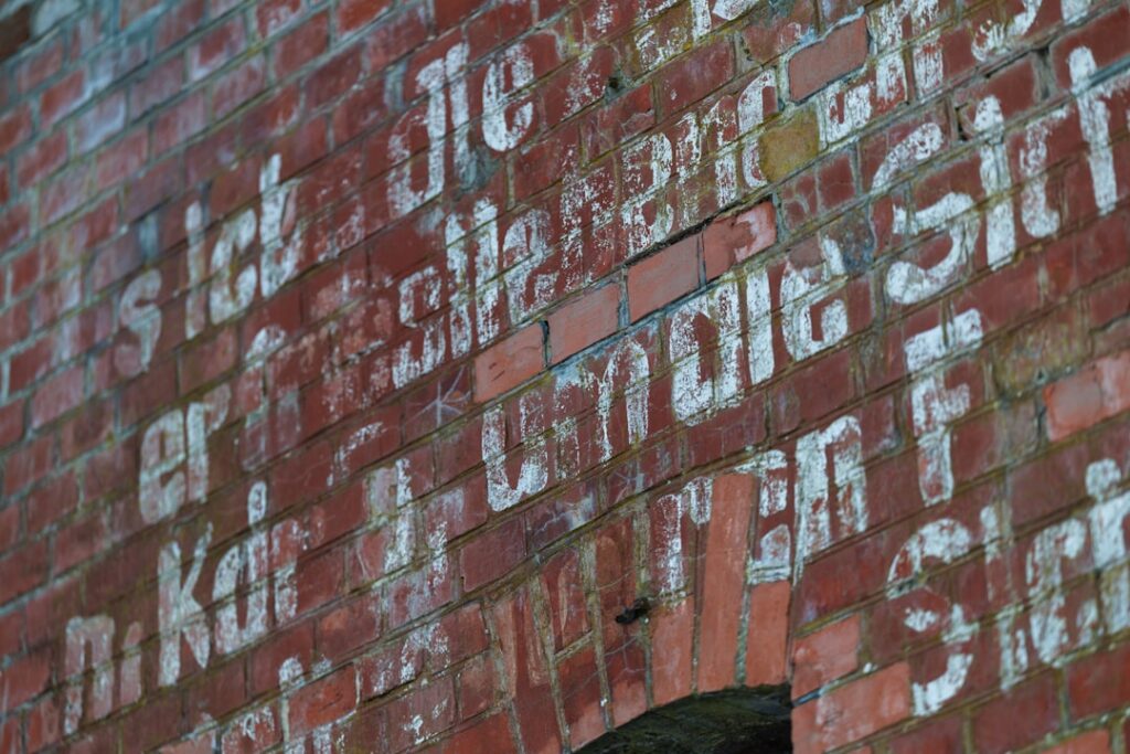 White text painted on a red brick wall