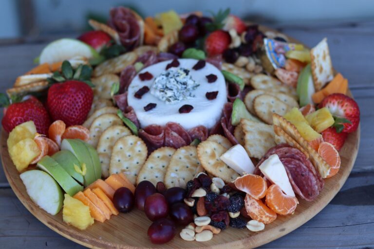Grazing board wooden platter cheese vegetables fruit detail