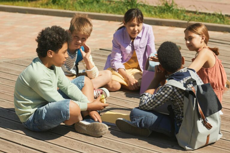 School friends talking playground kid sitting alone school
