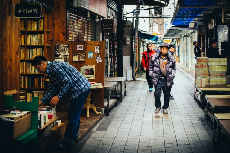 Used bookshop exterior narrow street people browsing secondhand
