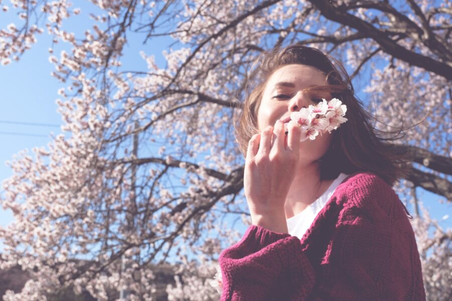 Woman sneezing tissue blooming trees spring pollen