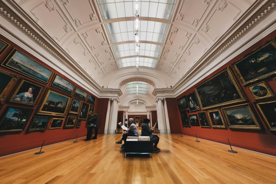 Museum gallery interior visitors benches paintings