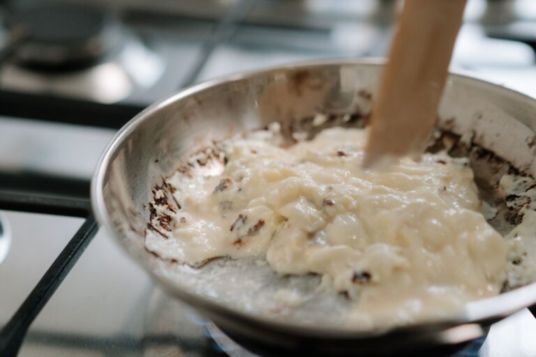 Pan sauce stainless steel skillet wooden spoon detail