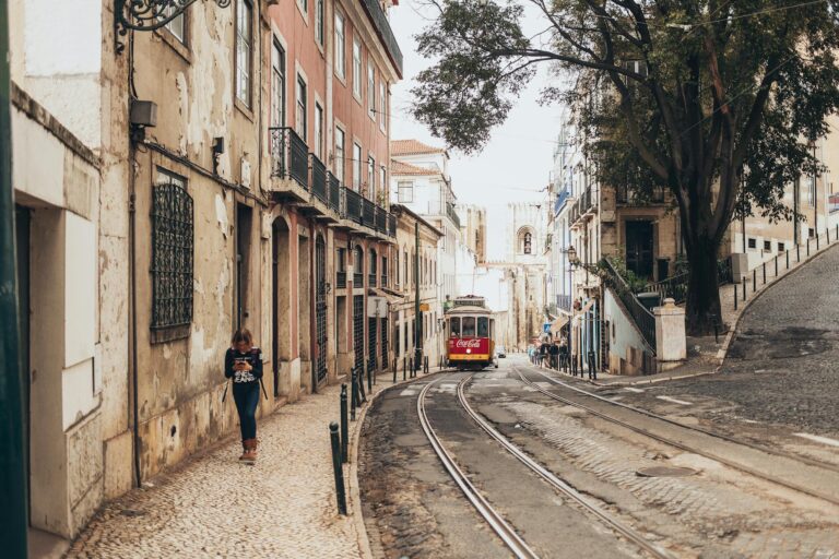 Lisbon tram narrow street pastel buildings
