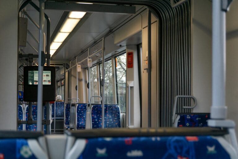 Tram interior commuters handrails city detail