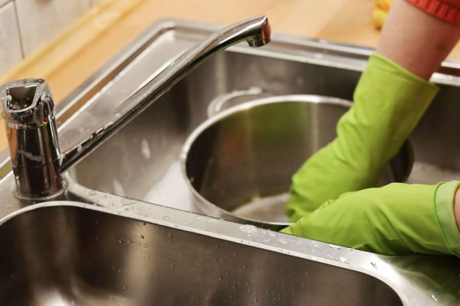 Homeowner fixing kitchen sink leak tools