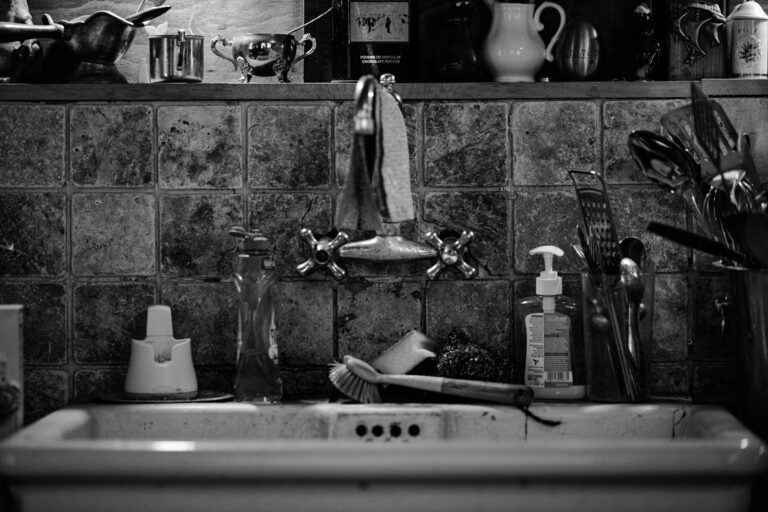 Homeowner fixing kitchen sink leak tools