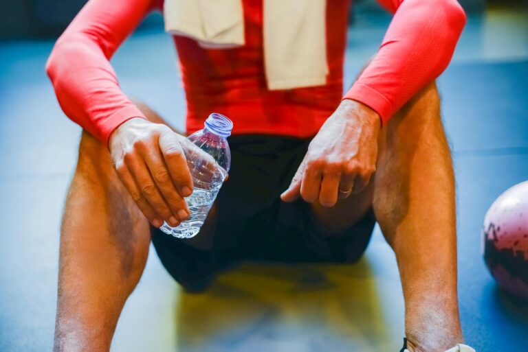 Athlete resting gym floor water bottle towel detail