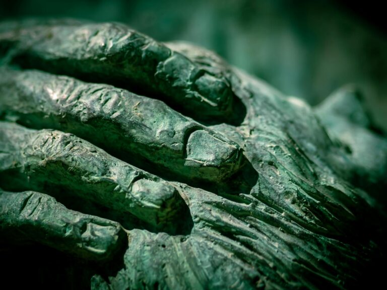 Hands touching sculpture