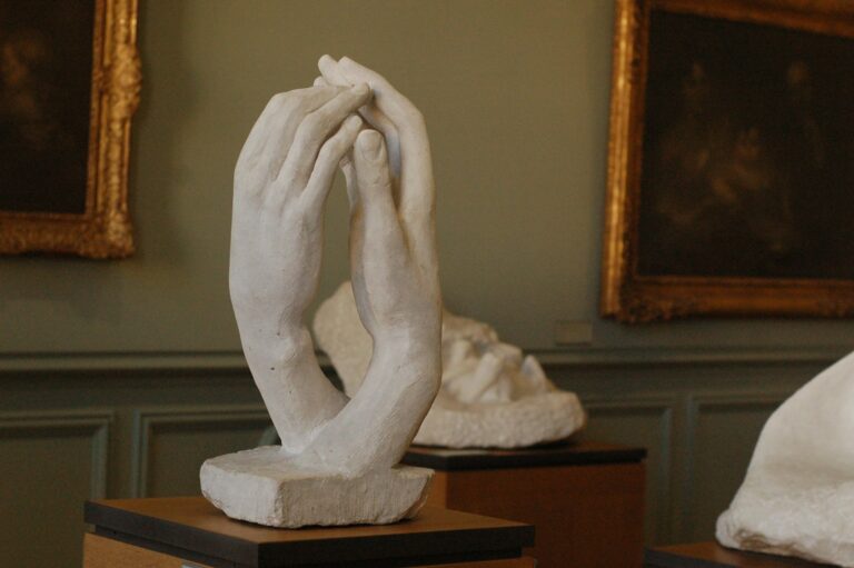 Hands touching sculpture